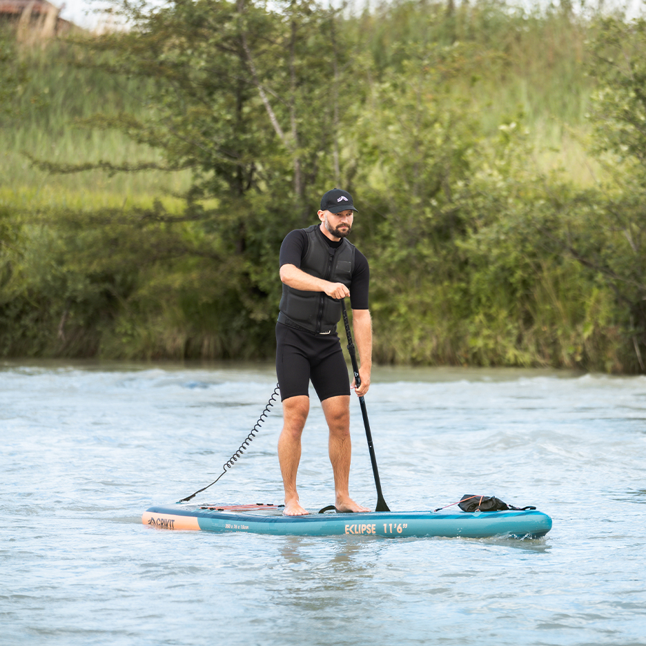 Mann auf Crivit Eclipse 11'6' Paddleboard mit Schwimmweste und Paddel.