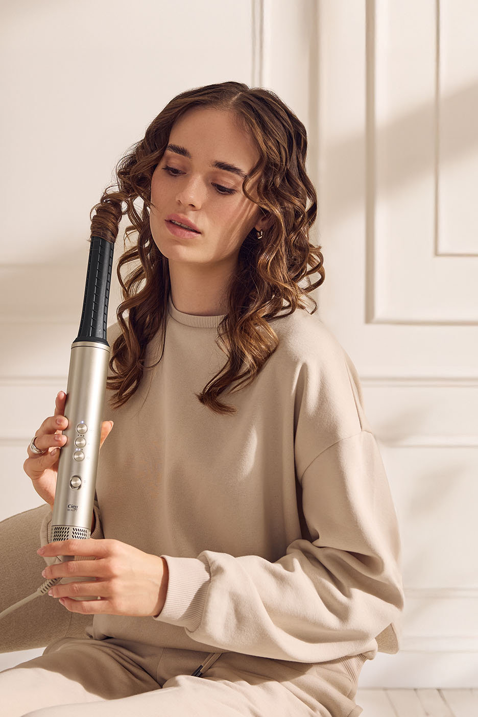 Frau mit Lockenwickler von Cien Beauty, der ihre Haare lockt.