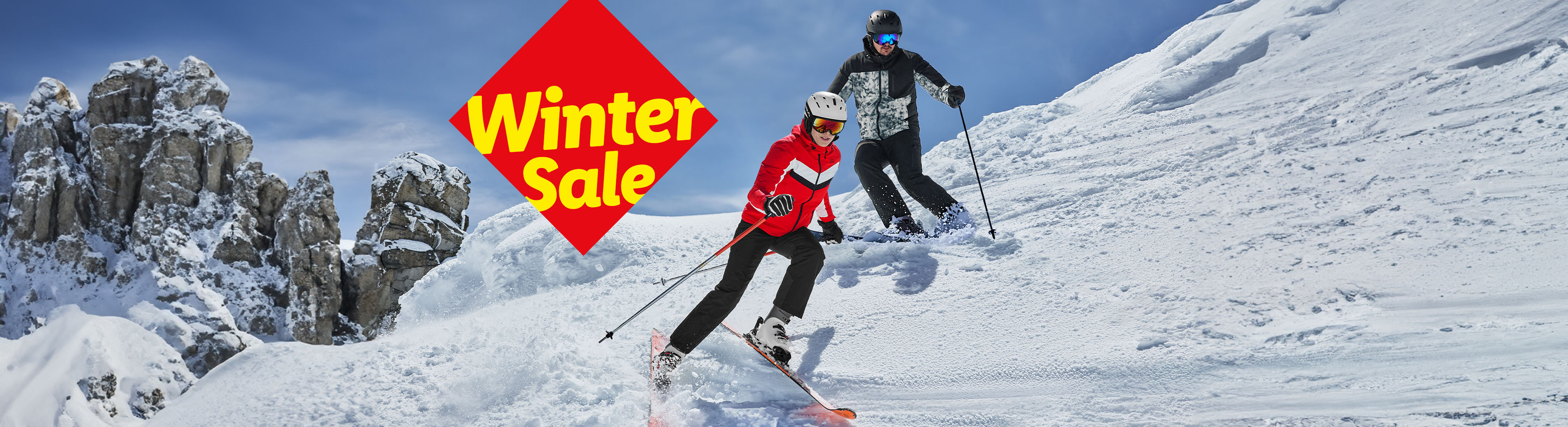 Zwei Skifahrer auf einer Skipiste mit Felsen im Hintergrund und einem roten Banner mit der Aufschrift „Winter Sale“.