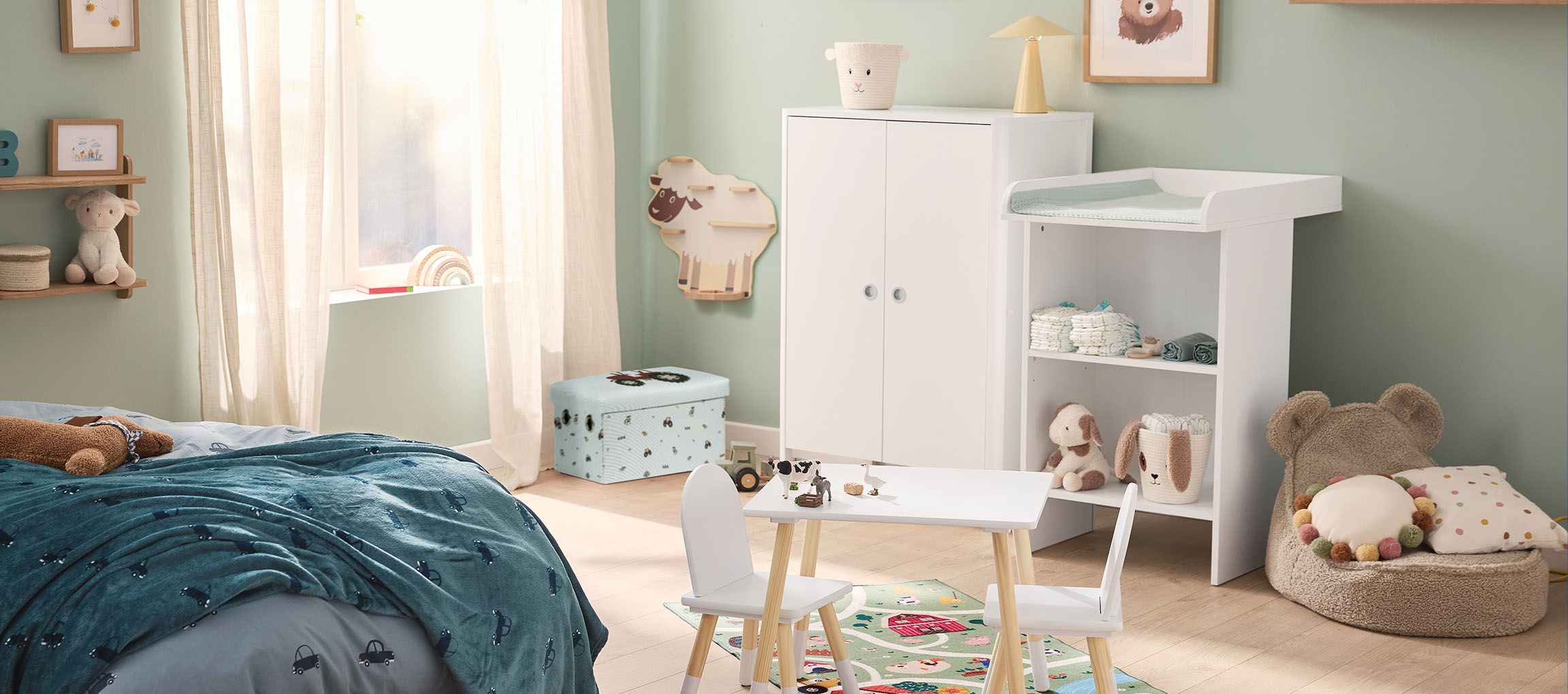 Ein Kinderzimmer mit Bett, Wickeltisch, Kleiderschrank und einem kleinen Tisch mit Stühlen.