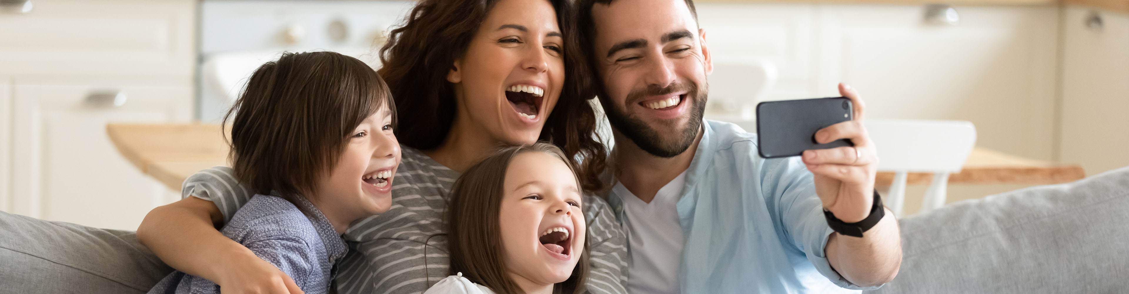Eine glückliche Familie macht ein Selfie mit ihrem Smartphone.