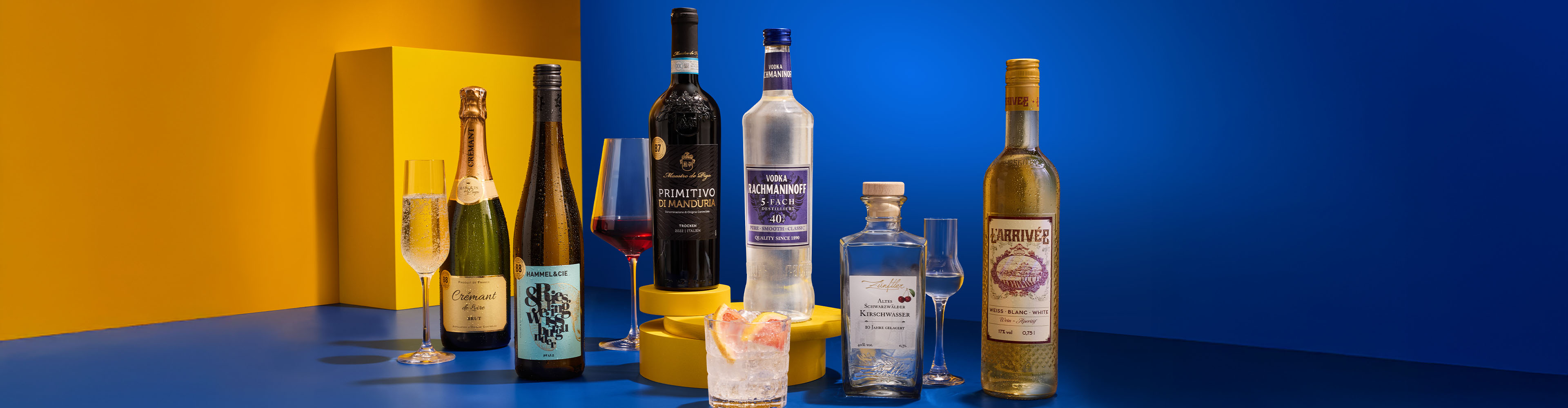 Eine Auswahl an Weinen, Spirituosen und Cocktails auf gelb-blauem Hintergrund.
