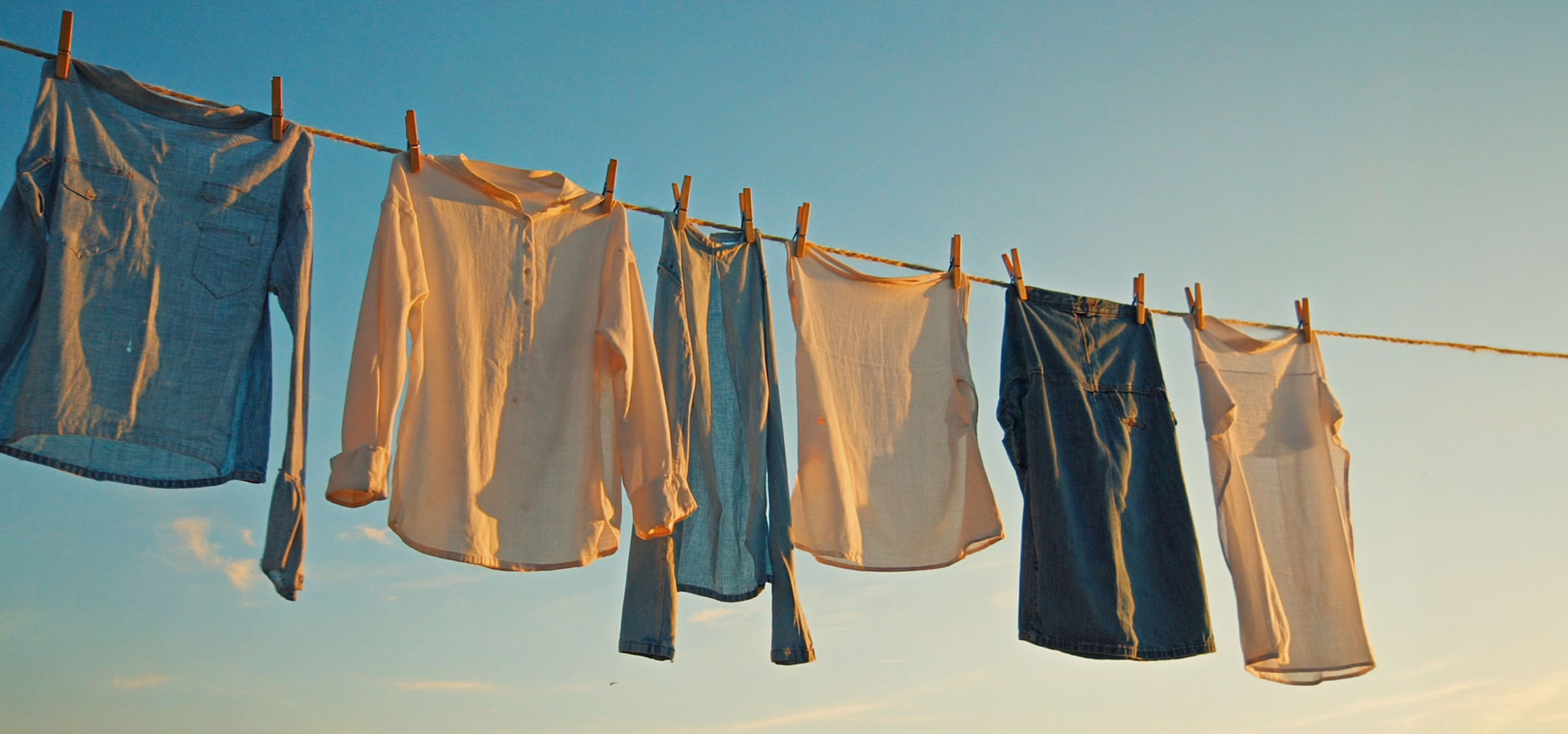 Wäsche trocknet an der Leine: Hemden und Jeans.