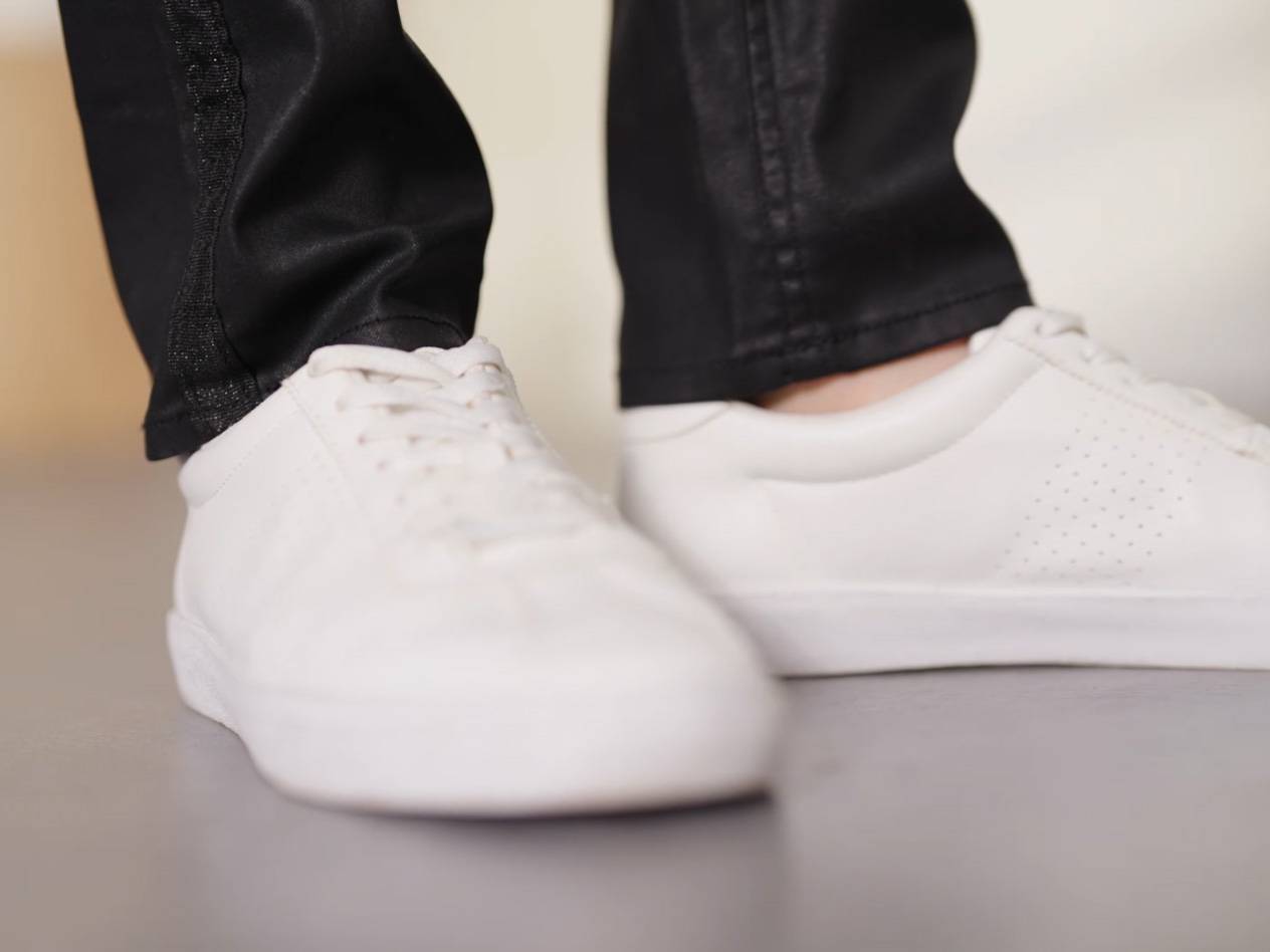 Weiße Sneakers mit schwarzer Hose.