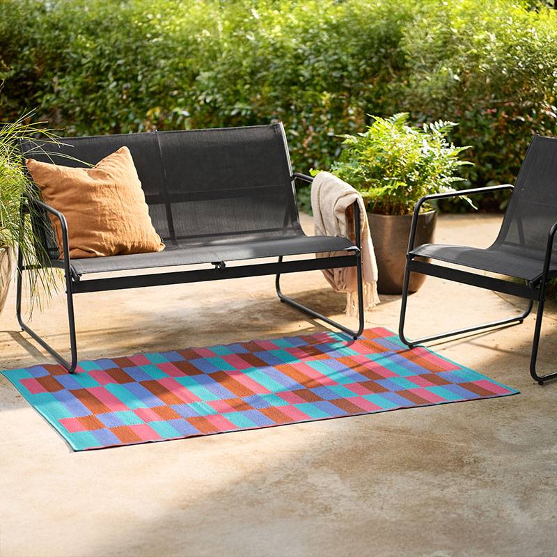 Gartenmöbel und geometrischer Teppich.
