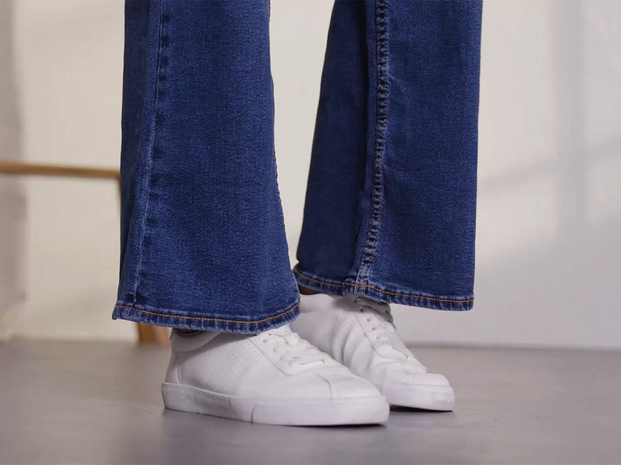 Blaue Jeans und weiße Sneaker.